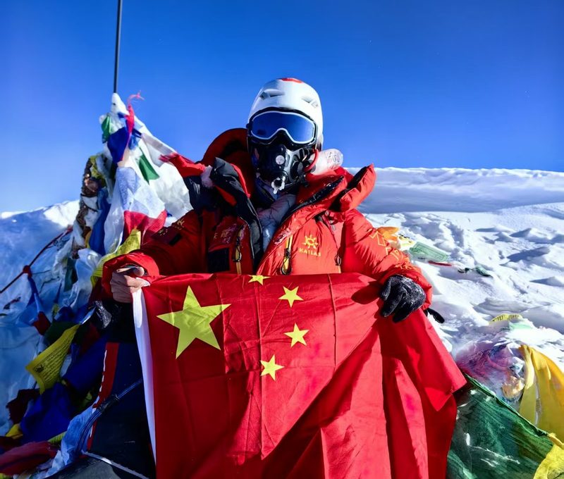 朱霞(考拉姐)手持国旗于 2023 年 5 月 18 日登顶珠穆朗玛峰